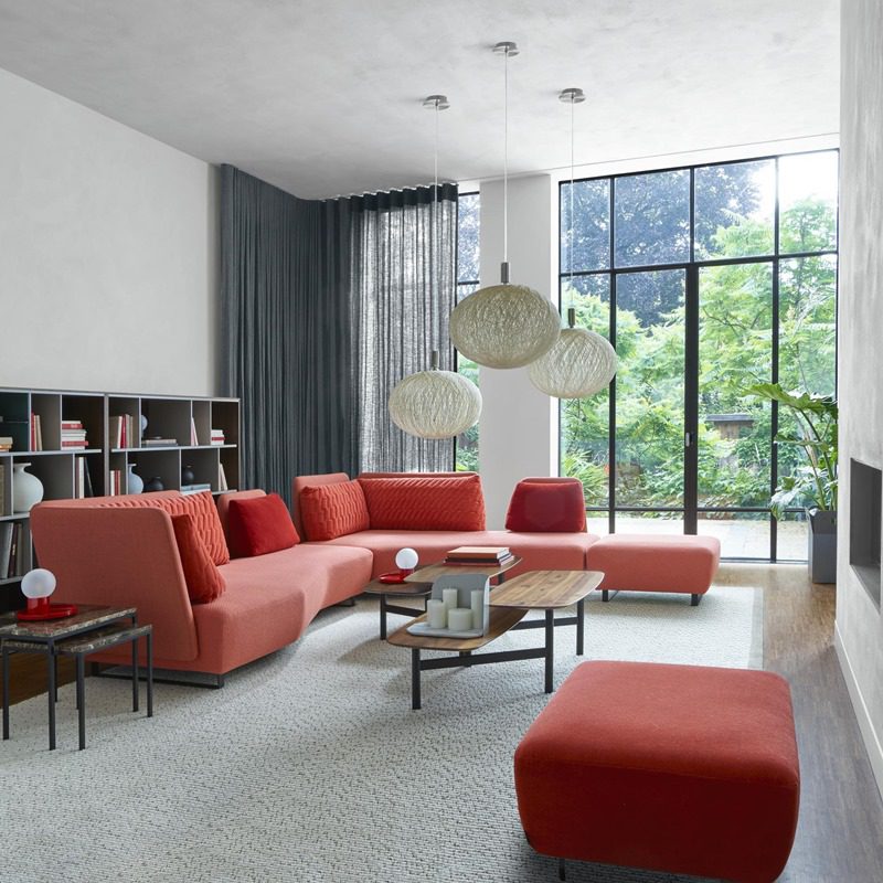 3887_L_imprevu_living_coral_pink_right_corner_sofa_in_bright_living_room_white_carpet_chandelier_bookcase_ligne_roset_fino_malta_1.jpg